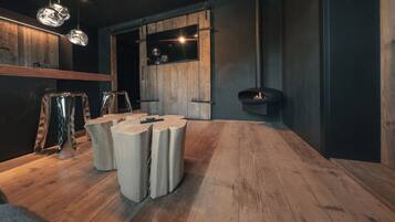 Ein modernes Interieur mit Holzboden, einem runden Tisch mit Hockern und Pendelleuchten.