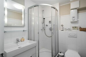 A modern bathroom with a glass-enclosed shower, a white sink, and a toilet. - Holiday apartment with 1 bedroom (Westerland - Sylt)