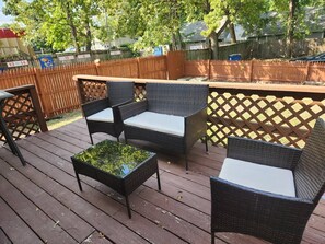 Eine Terrassengruppe mit Korbmöbeln und einem Tisch.