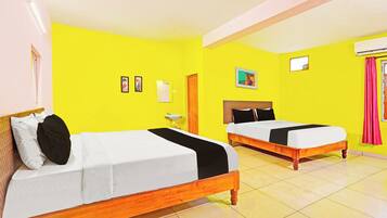 A hotel room with two beds, a sink, and a window with curtains.