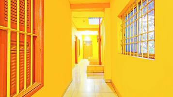 A corridor with a tiled floor and yellow walls.