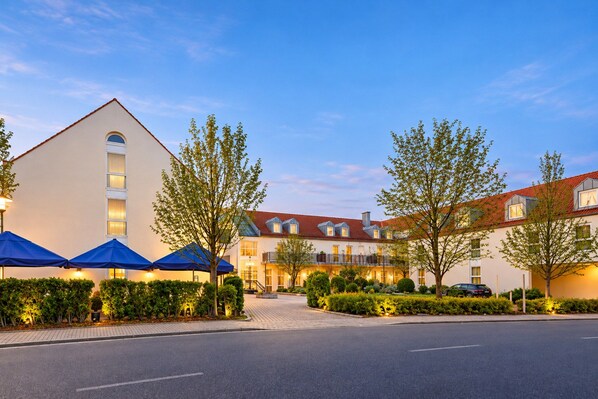 Ein Hotel mit Innenhof, mehreren Balkonen und einer überdachten Außenbereich-Sitzgelegenheit.