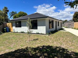 A modern single-story house with a flat roof, large windows, and a well-maintained lawn. - Beautiful and spacious house in Doveton (Doveton)