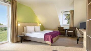 Ein Hotelzimmer mit einem Bett, einem Schreibtisch und einem Stuhl.