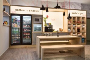 Ein Café-Interieur mit einem Bereich für Kaffee und Snacks, einer Schnellabholestation und einer Sitzbank.