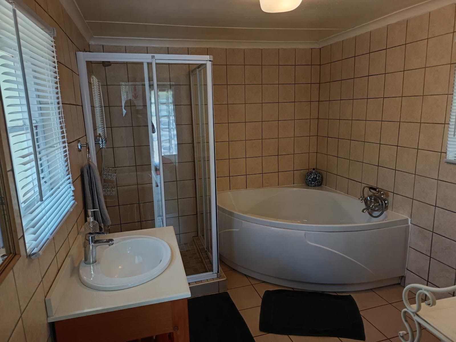 A bathroom with a bathtub, a glass-enclosed shower, and a sink.