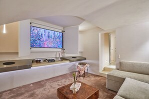 Ein modernes Wohnzimmer mit einem Flachbildfernseher, einem Sofa, einem Couchtisch und einem Bücherregal.