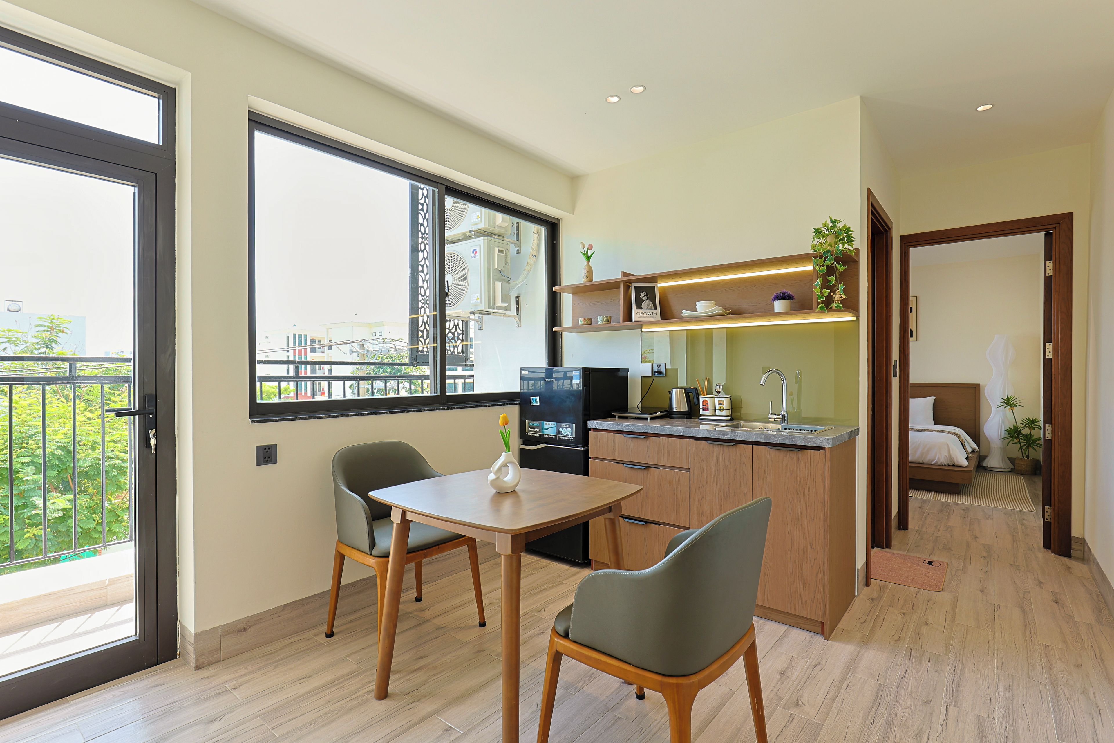 En moderne lejlighed med spiseområde, køkken og en balkon med udsigt over byen.