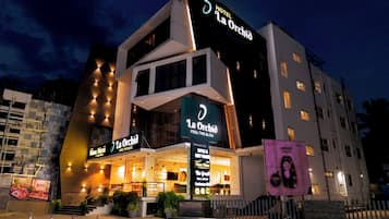 Un hotel de diversos pisos amb un cartell ben visible de 'Hotel La Orchia' i una entrada ben destacada.