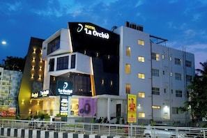 Un hotel de varios pisos con un letrero llamativo que dice 'HOTEL La Orchid'.