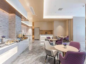 A modern hotel dining area with marble flooring, a buffet station, and contemporary furniture. - Lavande Hotel (Xiamen)