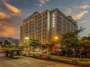 A multi-story hotel with a prominent entrance and a well-lit facade. - Lavande Hotel (Xiamen)