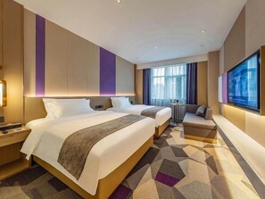 A hotel room with two beds, a seating area, a TV, and a large window. - Lavande Hotel (Xiamen)