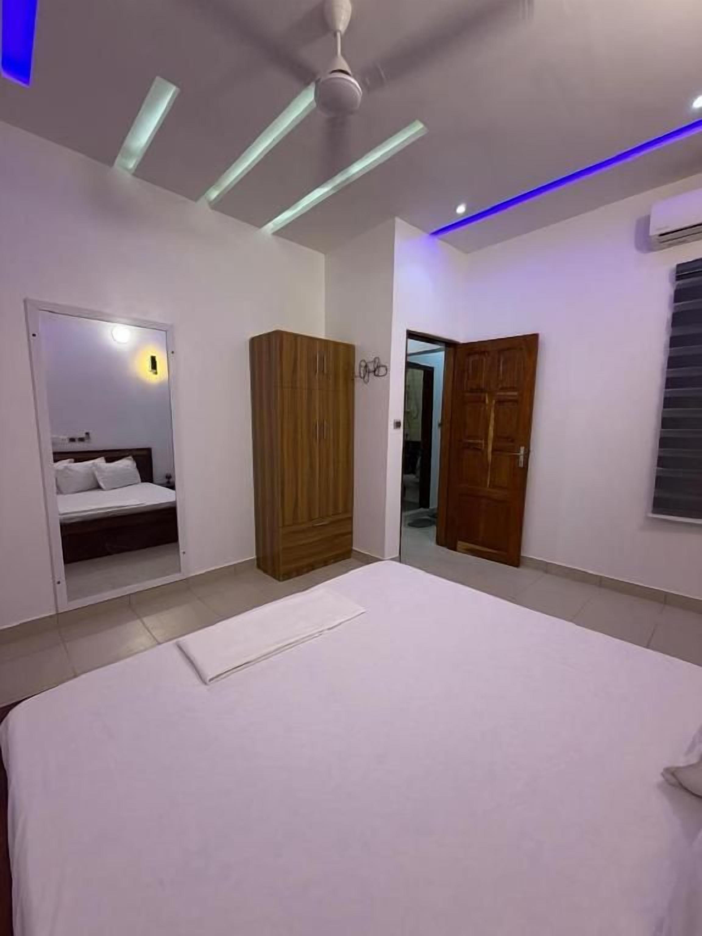 Quarto com cama, guarda-roupa e espelho.