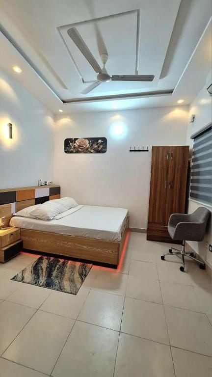 Un dormitorio moderno con cama, mesita de noche, armario y ventilador de techo.