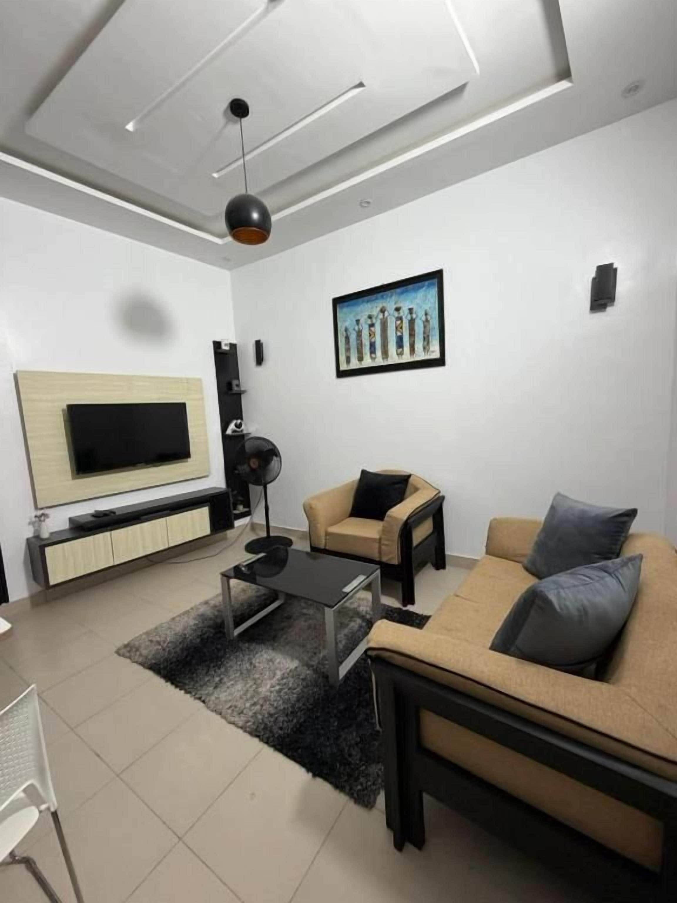 A modern living room with a sofa, a coffee table, and a TV.