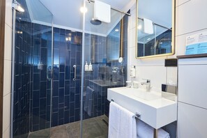 A modern bathroom with a glass-enclosed shower, a white sink, and a large mirror. - Holiday Inn Express Istanbul - Airport Arnavutkoy (Arnavutköy)