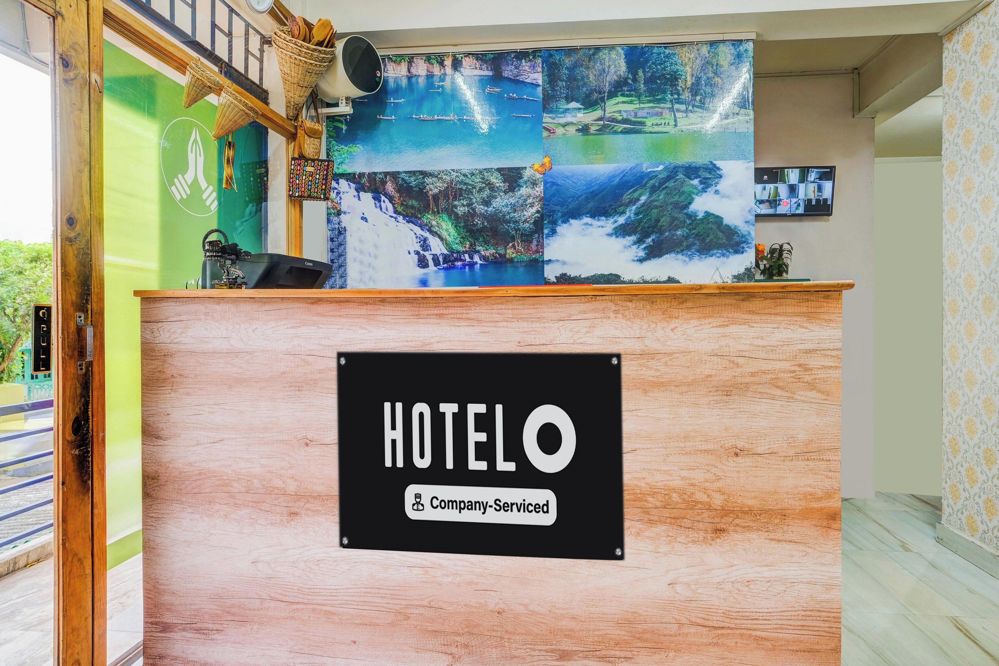 A hotel reception desk with a sign indicating it is company-serviced.