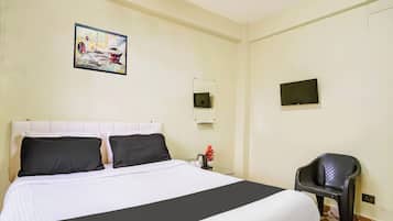 Une chambre d’hôtel avec un lit, une chaise, un tableau, un miroir et un téléviseur.