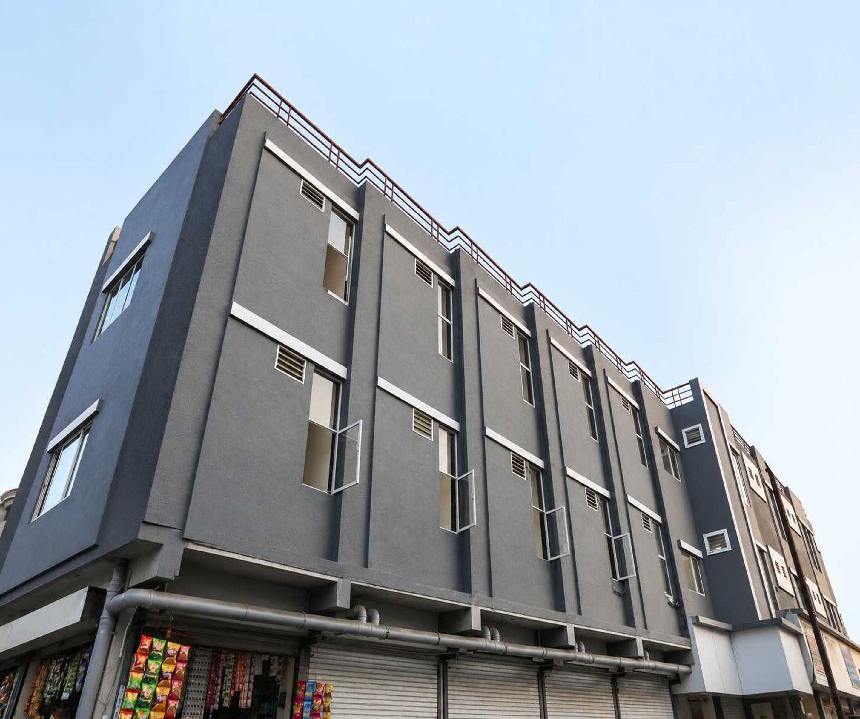 Een meerlaags gebouw met een modern architectonisch ontwerp, met een reeks ramen en een zichtbare winkelpui op de begane grond.