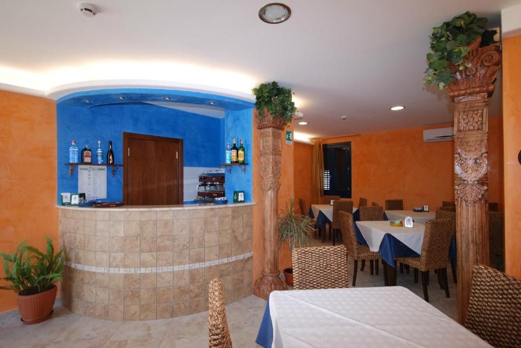 Un hall de hotel con mostrador de recepción, zona de estar y un bar.