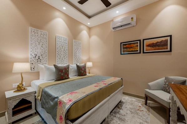 A bedroom with a bed, bedside tables, a desk, and a chair. - Justa Luxe Kashi Parampara, Varanasi (Varanasi)