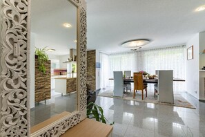 A modern kitchen with a dining area, a large ornate mirror, and a plant. - Holiday apartment with 1 bedroom (Gaienhofen)