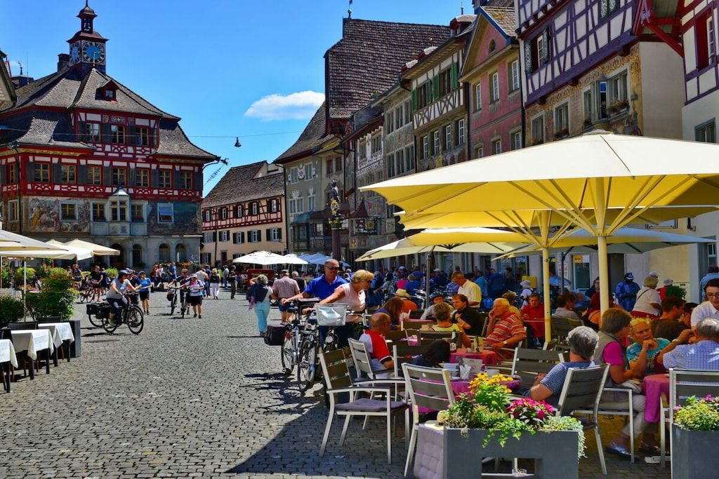 A cobblestone street with outdoor seating and bicycles.