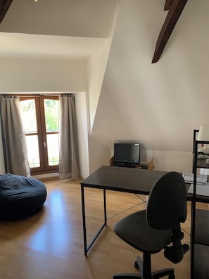 A room with a desk, chair, and bean bag. - New Listing (Pleaux)