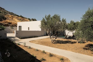 A modern building with a white facade, a paved driveway, and a small pool area. - Mitos Ultimate Escape Villa (Naxos)