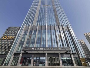 A high-rise building with a modern glass facade and a prominent entrance labeled 'Mercure'. - Mercure Lanzhou Downtown (Lanzhou)