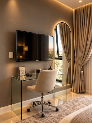 A modern bedroom with a glass desk, a mounted TV, a comfortable chair, and a large window with curtains. - The Onyx Sandton Gate 2BR Luxury Stay. (Sandton)