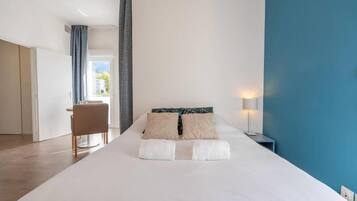 Una habitación de hotel con una cama, un escritorio y una silla.