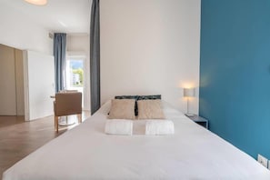 Una habitación de hotel con una cama, un escritorio y una silla.