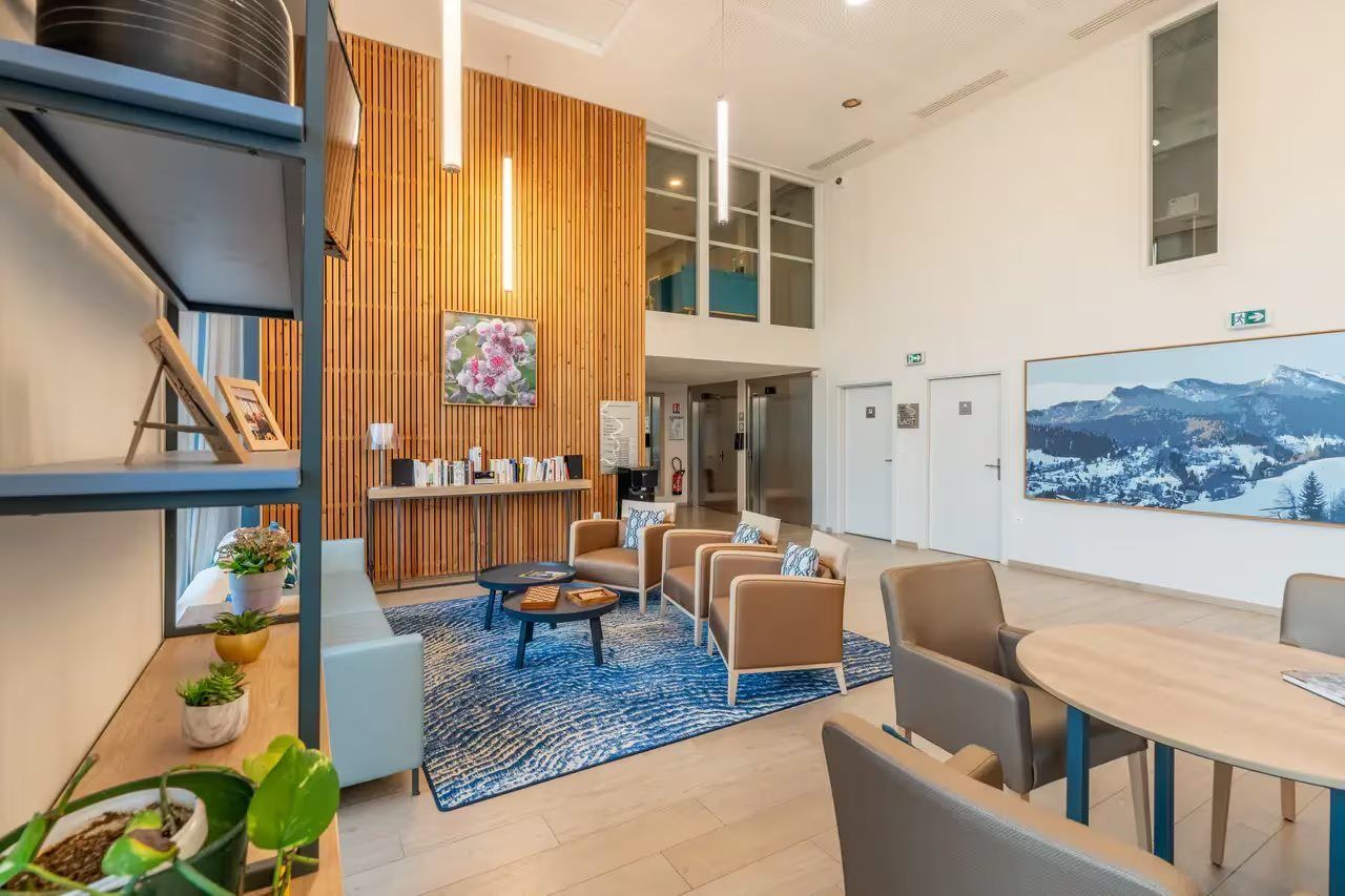 A modern lobby with a wooden accent wall, seating area, and a large framed picture.