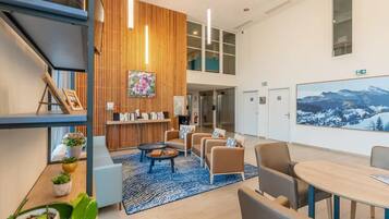 A modern lobby with a wooden accent wall, seating area, and a large framed picture.