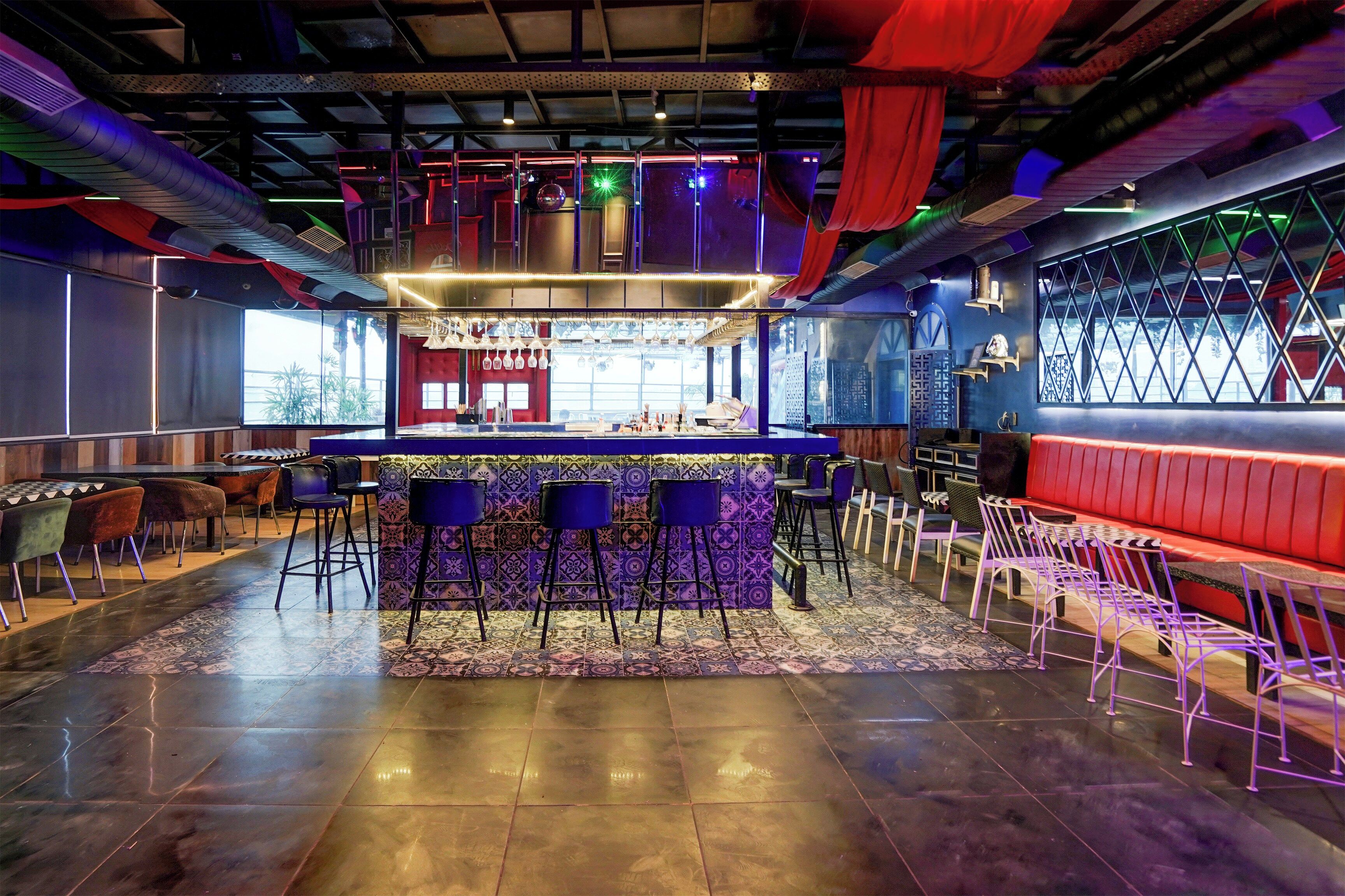 A bar area with a counter, stools, and a patterned floor.
