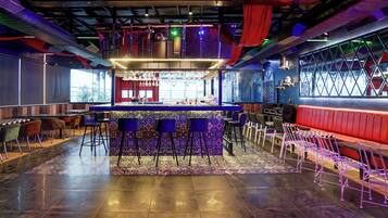 A bar area with a counter, stools, and a patterned floor.
