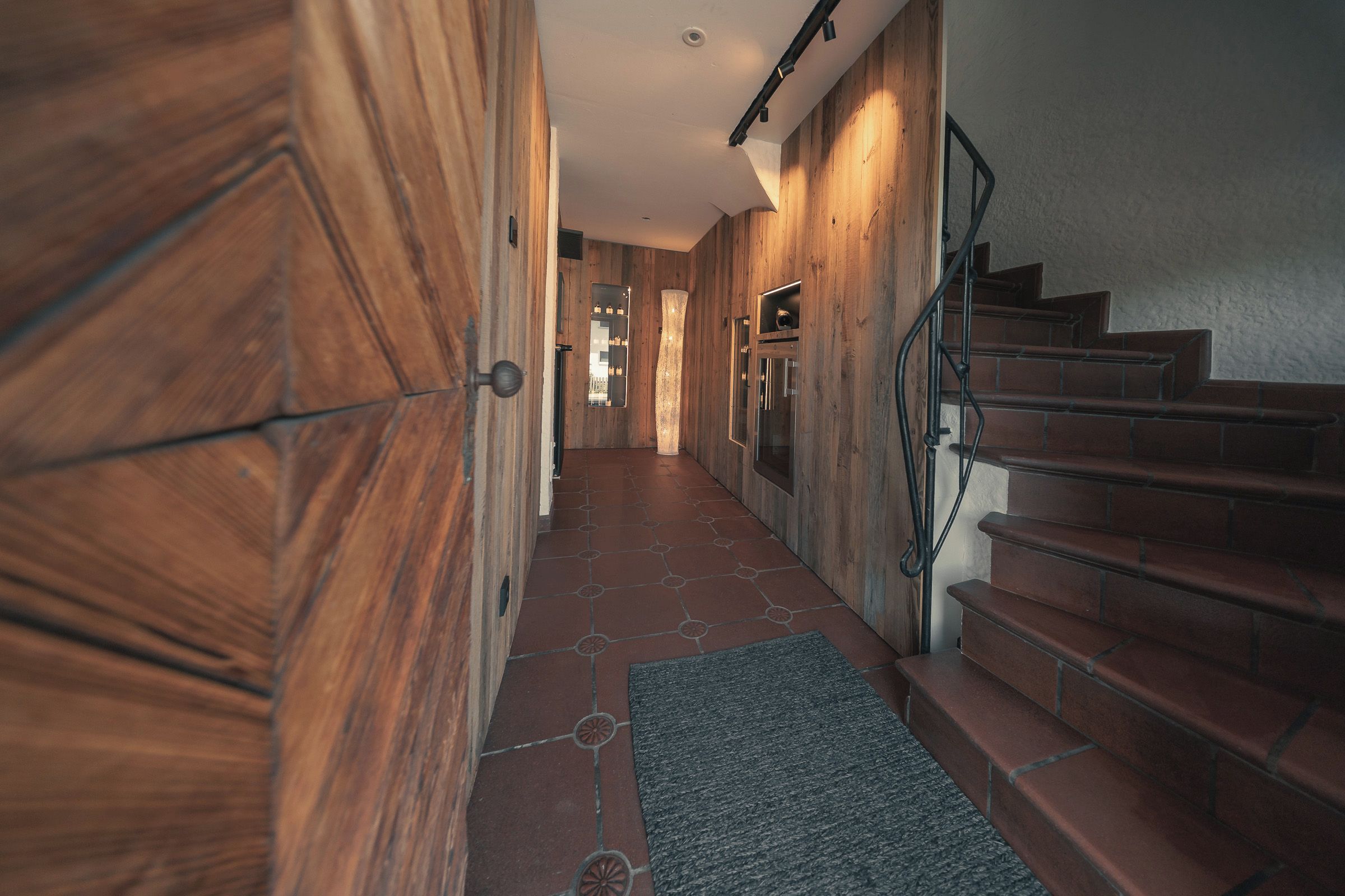 Ein hölzerner Flur mit einer Treppe, die zu einer Zwischenebene führt.