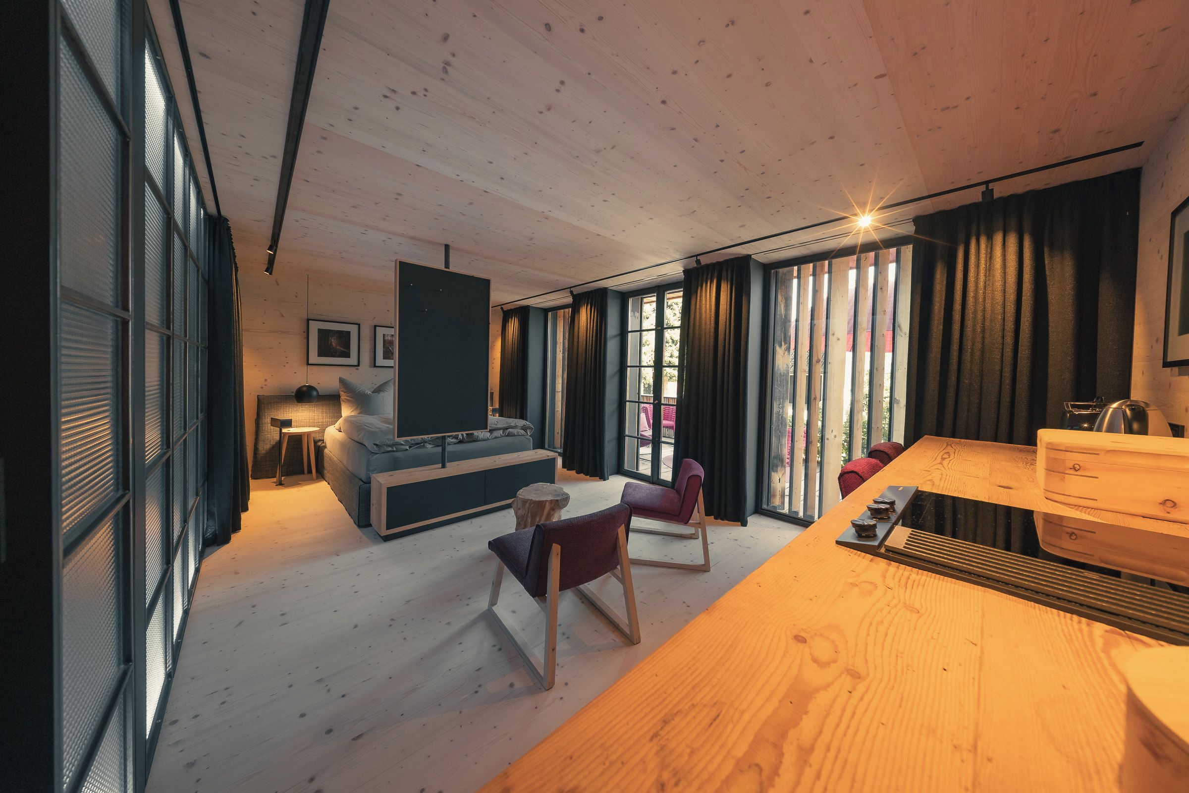 Ein modernes Wohnzimmer mit einer Couch, Sesseln, einem Couchtisch und einem Kamin.