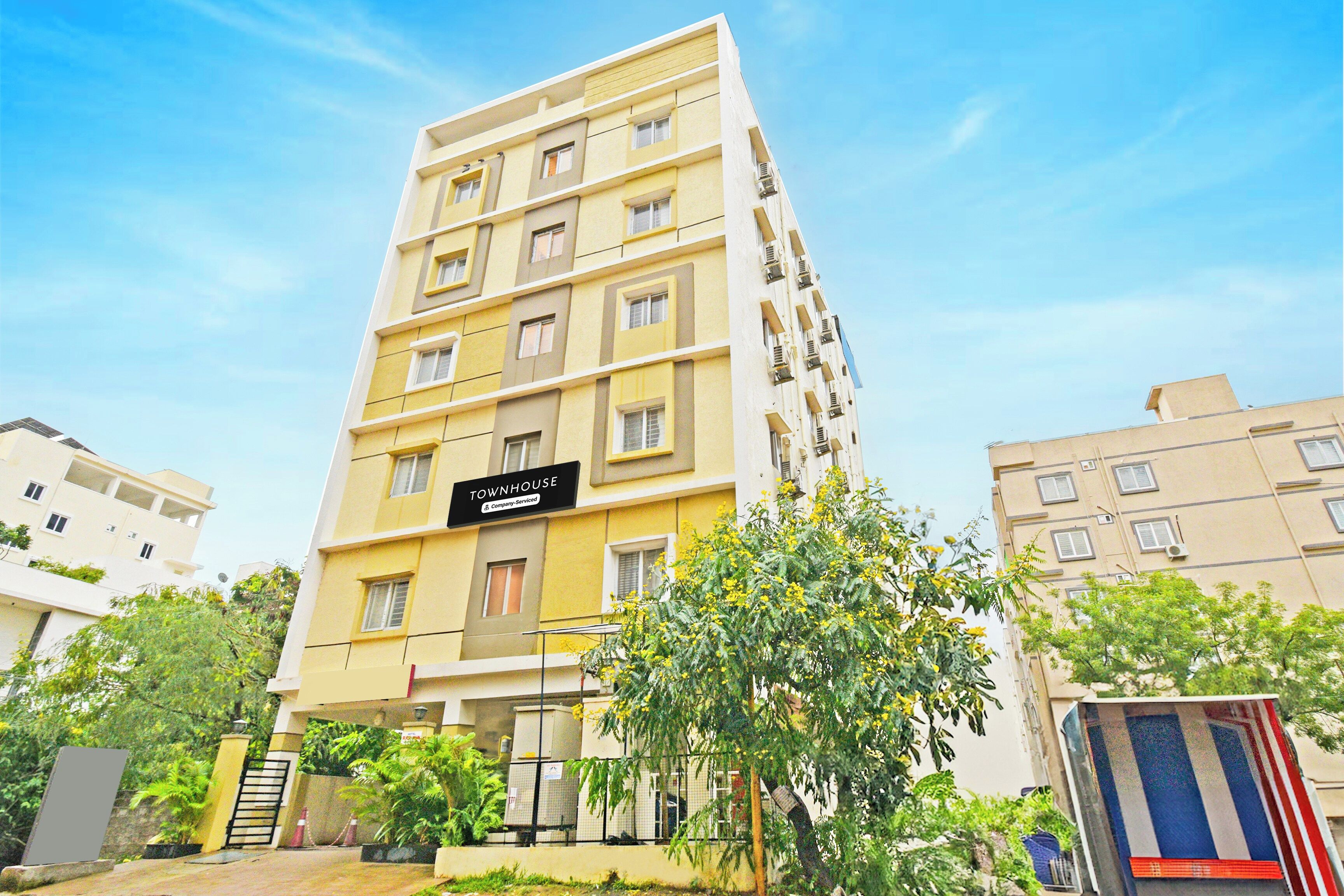 A multi-story residential building with a sign indicating it is a serviced apartment.