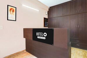 A hotel reception desk with a sign indicating it is company-serviced.