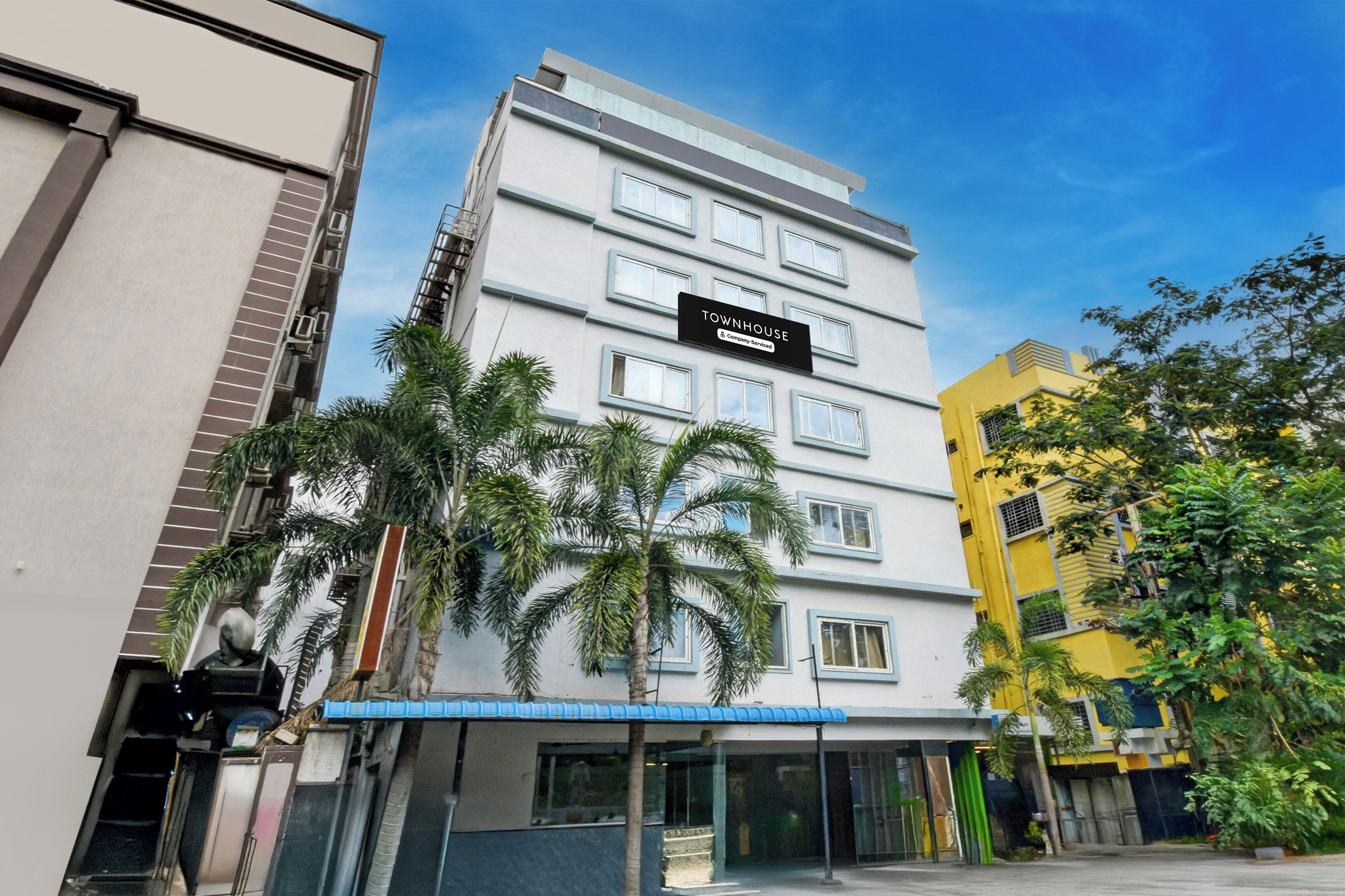 Un edificio de varios pisos con un letrero que dice 'TOWNHOUSE & Company Serviced'.