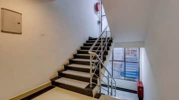 A staircase with metal railings and a fire hose reel on the wall.