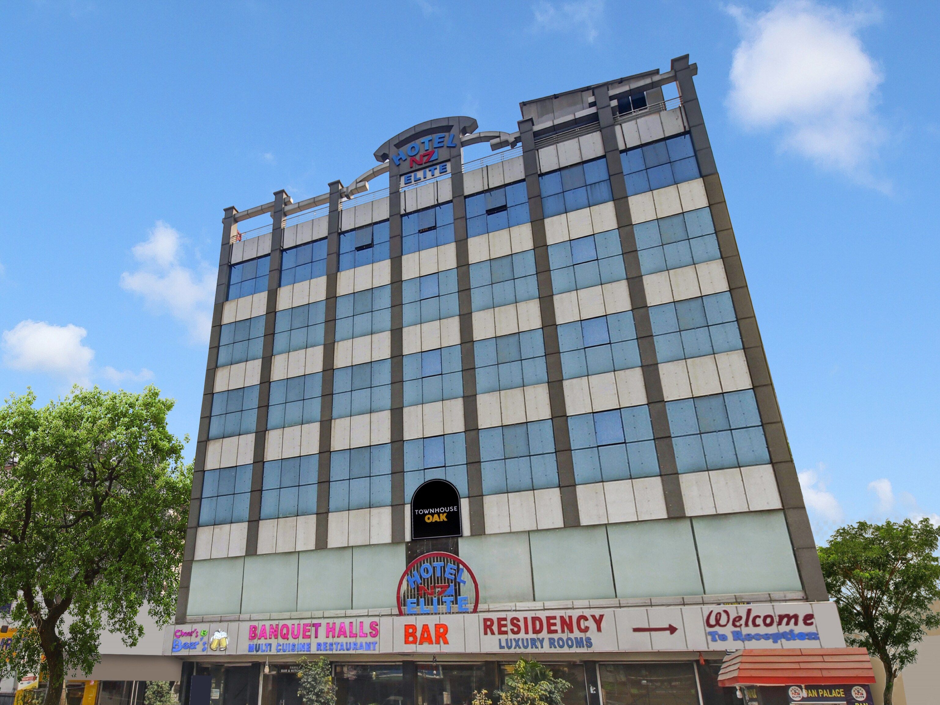 A multi-story hotel with a sign for 'Hotel NZ Elite' and a 'Townhouse Oak' sign below.
