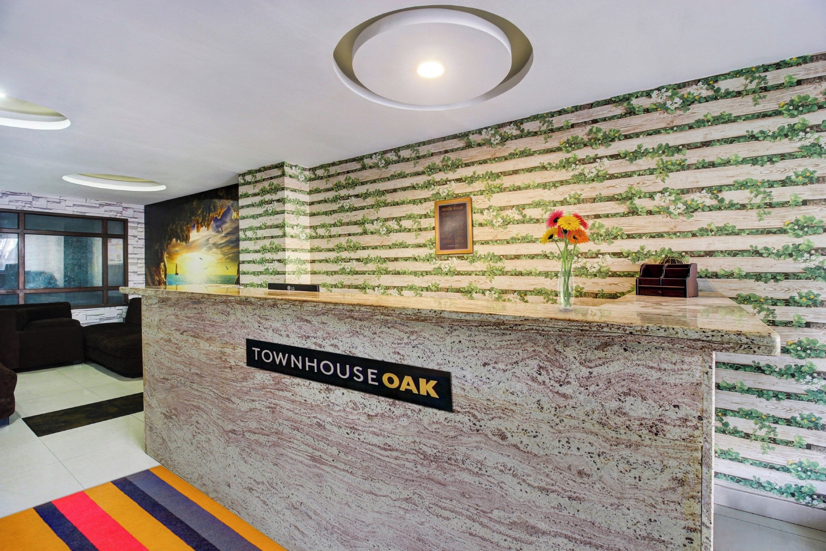 A reception desk with a sign reading 'Townhouse Oak' and a framed 'House Rules' sign.