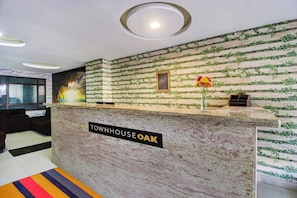A reception desk with a sign reading 'Townhouse Oak' and a framed 'House Rules' sign. - Townhouse Oak LB Nagar Ramoji (Hyderabad)