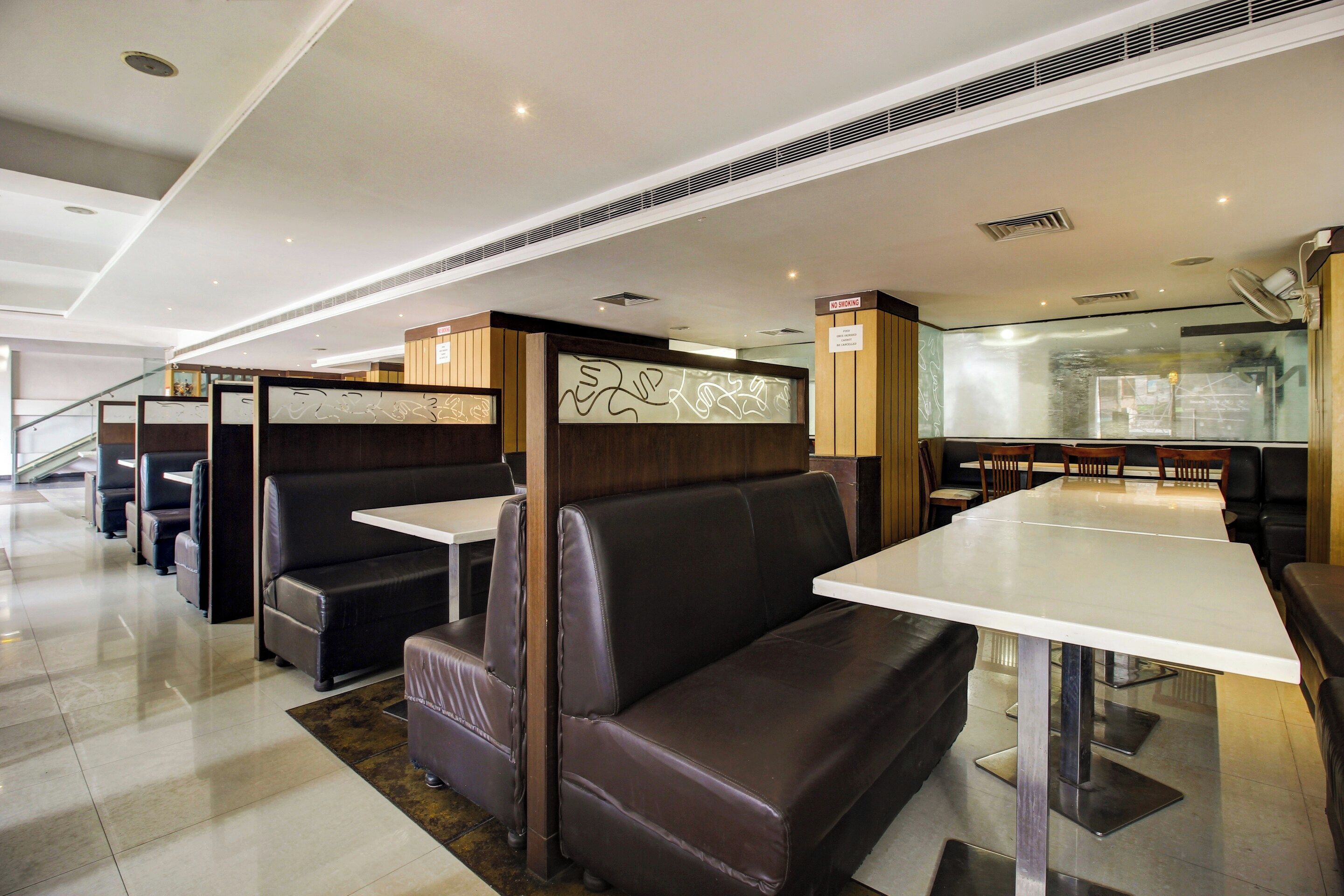 Un interior de restaurante moderno con asientos tipo cabina y mesas altas.