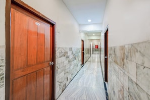 Passadís amb sòl de marbre i portes de fusta, que condueix a diverses habitacions.