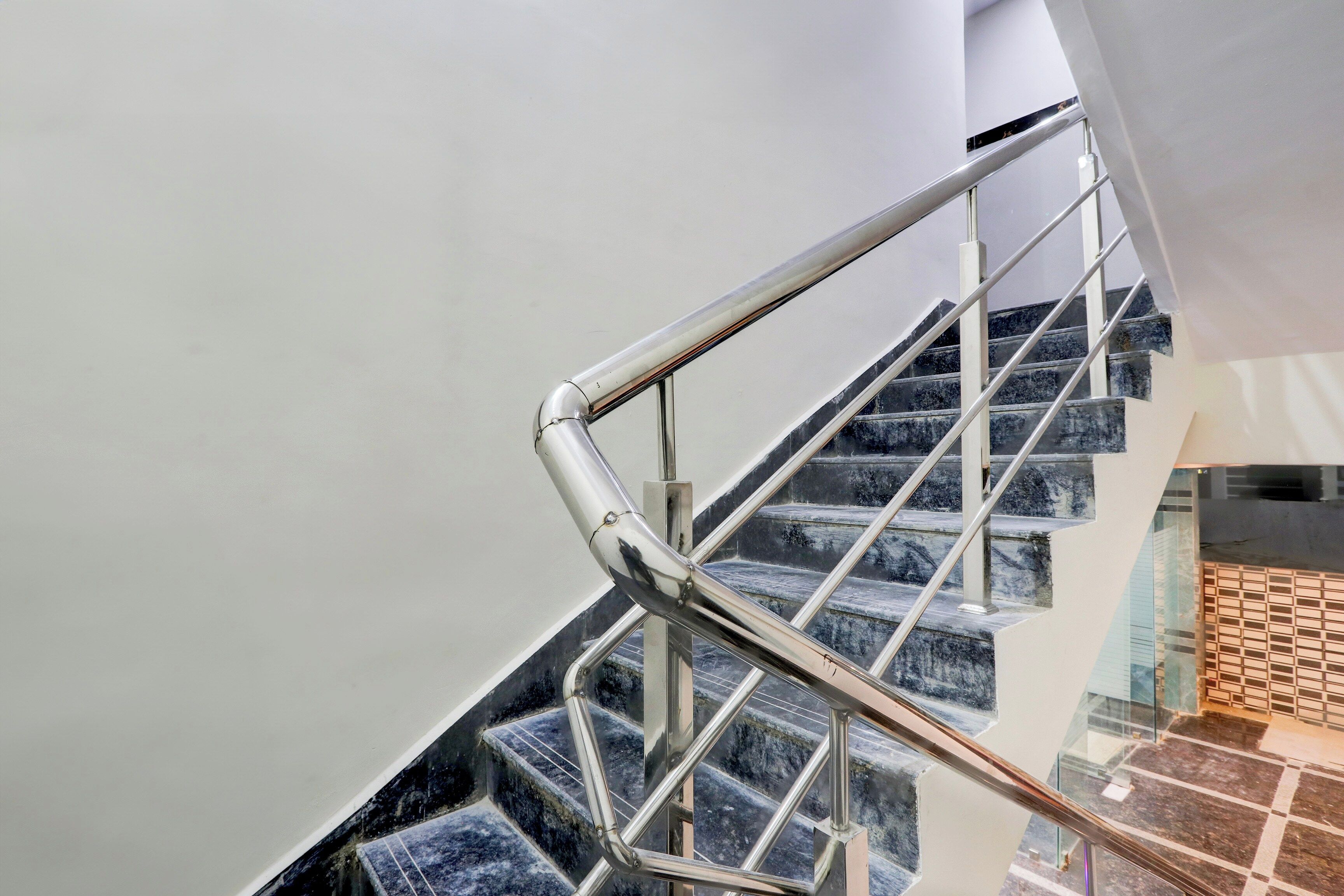 A staircase with a metal handrail and marble steps.